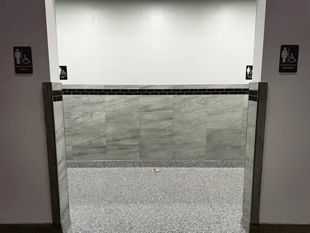 Flooring and half-tiled wainscoting work on a commercial bathroom