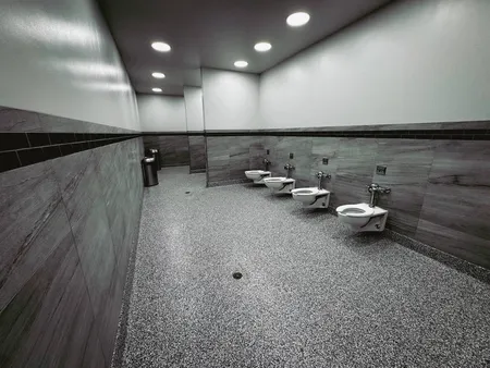 Flooring and half-tiled wainscoting work on a commercial bathroom